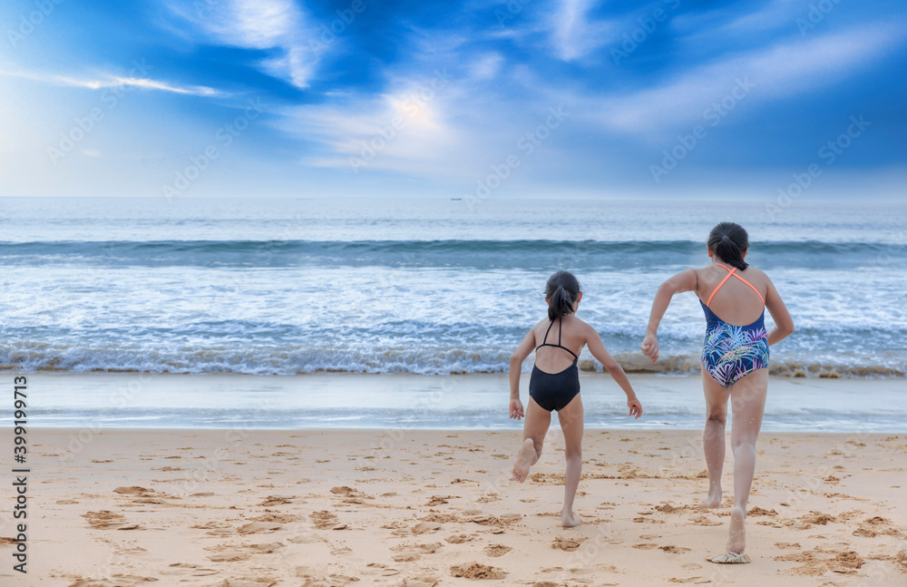 Stop motion happy two children wear swimwear running from beach to the sea. Happy family holiday summer concept. Two girl running to beach with copy space