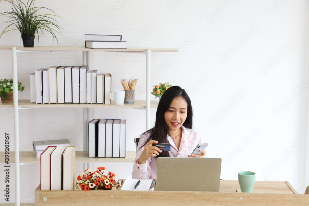 Asian woman using credit card for online banking service to purchase product from Internet with copy space Asian woman using credit card for online banking service to purchase product from Internet with copy space