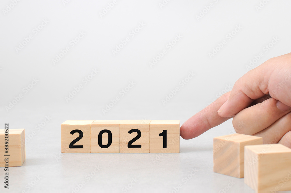 finger pointing to alphabet 2021 new year on wooden cube blocks with cement white background finger pointing to alphabet 2021 new year on wooden cube blocks with cement white background