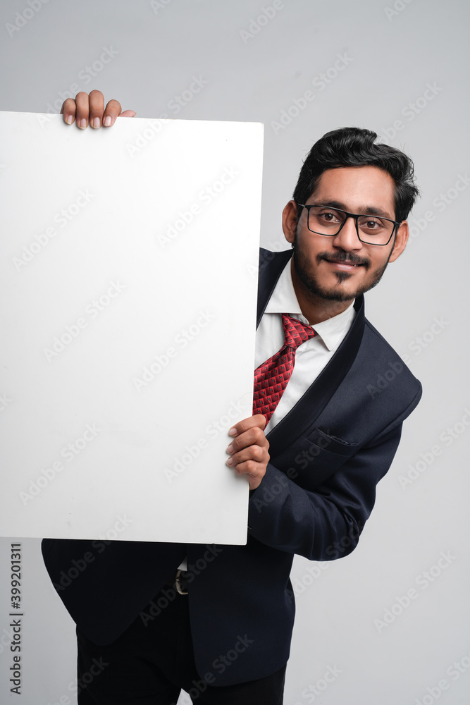 Young indian business man holding blank sign board Young indian business man holding blank sign board