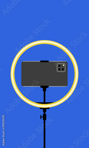 Dunkelgraues Smartphone in Ringleuchte vor blauem Hintergrund