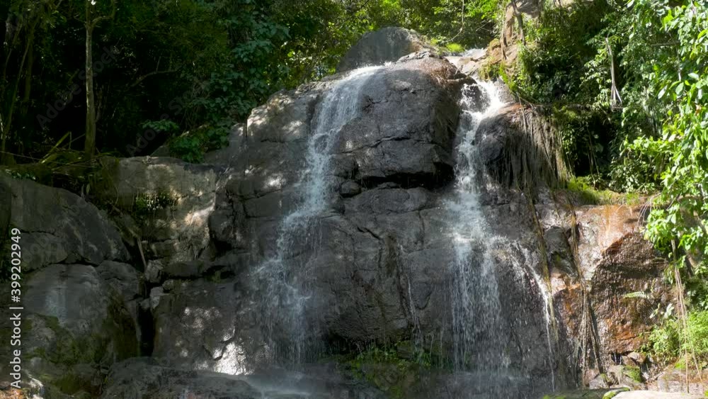 Waterfall in national park. Creek flows among rocks,. Stream over rocks in green forest Waterfall in national park. Creek flows among rocks,. Stream over rocks in green forest