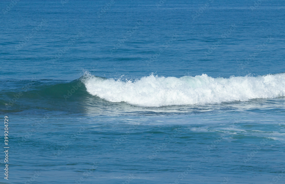 Breaking sea wave on a sandy beach background