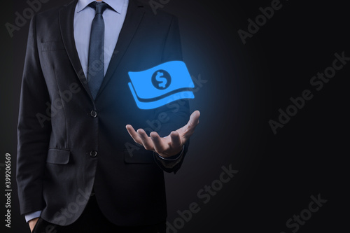 Businessman man holding money coin icon in his hands.Growing money concept for business investment and finance. USD or US dollar on dark tone background