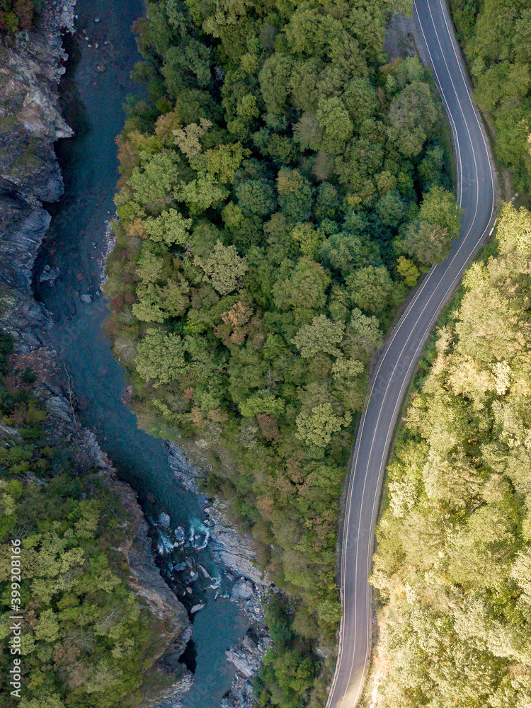 Road and mountain river through the green forest, Aerial view car truck drive going through forest, Aerial top view forest,