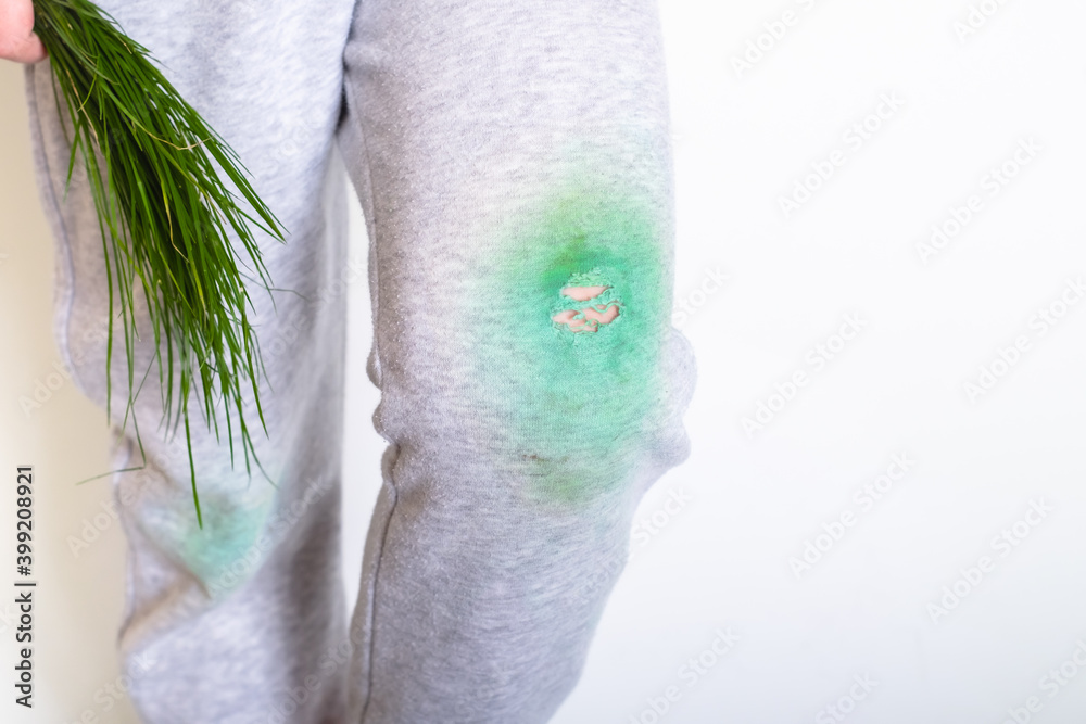 dirty stain from the grass on the baby's pants on a white background.place for text