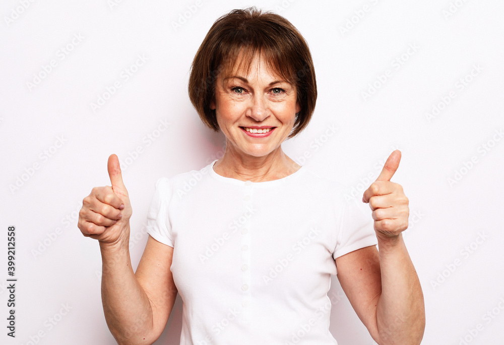 Old happy woman showing ok sign over white background Old happy woman showing ok sign over white background