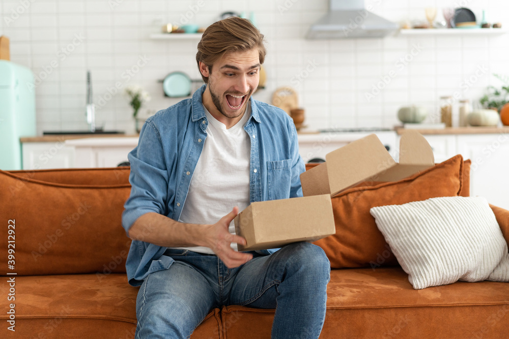 Happy man customer unpacking cardboard box receive open post mail delivery package
