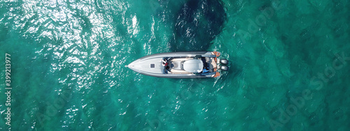 Aerial drone ultra wide top view panoramic photo of luxury inflatable rib speed boat anchored in exotic emerald bay with crystal clear sea