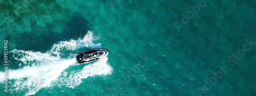 Aerial drone ultra wide photo of jet ski watercraft with couple cruising in high speed in Caribbean tropical exotic turquoise crystal clear sea © aerial-drone