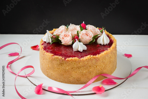 Strawberry cheesecake decorated rose flowers and merinques,  white and black background. Birthday cake, roses cake, ribbon and roses photo