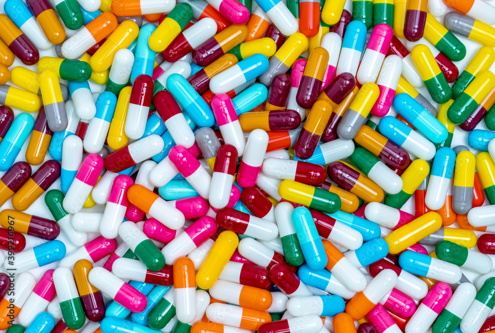 Many capsule pills. Top view capsule pills. Full frame blue, yellow, green, pink, red, orange, white, and gray capsule pills. Healthcare and medicine concept. Pharmaceutical industry. Health budget. Many capsule pills. Top view capsule pills. Full frame blue, yellow, green, pink, red, orange, white, and gray capsule pills. Healthcare and medicine concept. Pharmaceutical industry. Health budget.