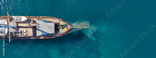 Aerial drone ultra wide photo of vintage sail boat anchored in mediterranean port © aerial-drone