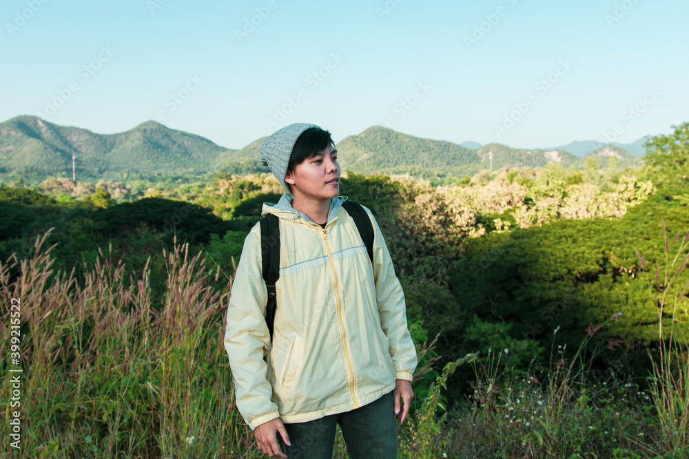Asian young men 25-30 year selfie standing with mountain blue sky landscape nature hiking outdoor at lamphun Thailand