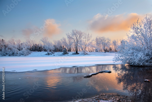 Evening on the river. Beautiful winter landscape with frost. Sunset, fog, haze