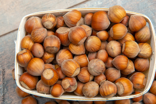 Hazelnuts in small crate on rustic background