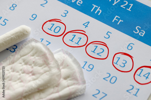 Sanitary pads and tampons are on calendar. Numbers are circled in red pen photo