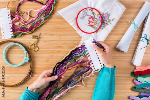 Hobby, crafting, creativity, time at home. Hands embroidering cross stitch