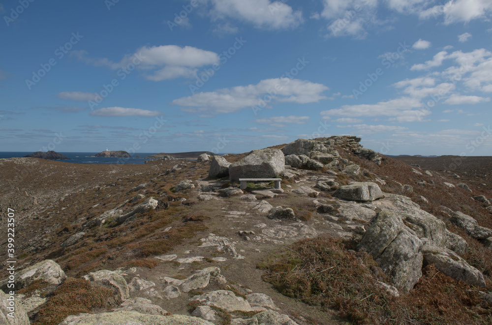 Wooden Bench on Top of a Cliff Surrounded by Granite Boulders with the Atlantic Ocean in the Background on the Island of Tresco in the Isles of Scilly, England, UK