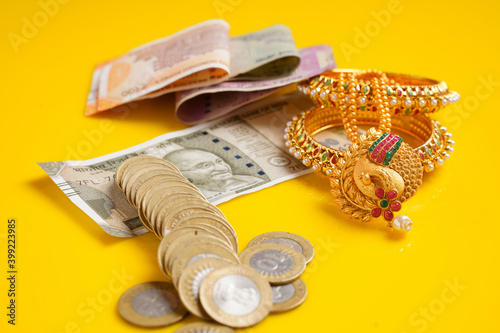 Fotografía Indian rupees note,coins and gold jewelry over yellow background