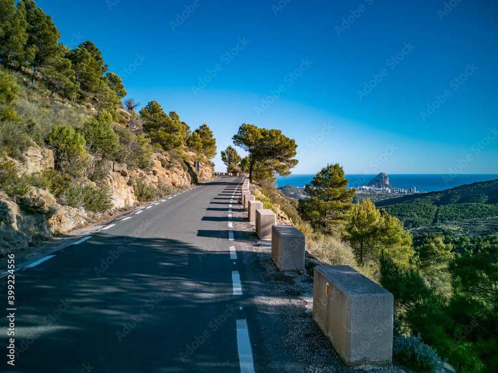 Mountain road with protection bollards near ifach boulder Mountain road with protection bollards near ifach boulder