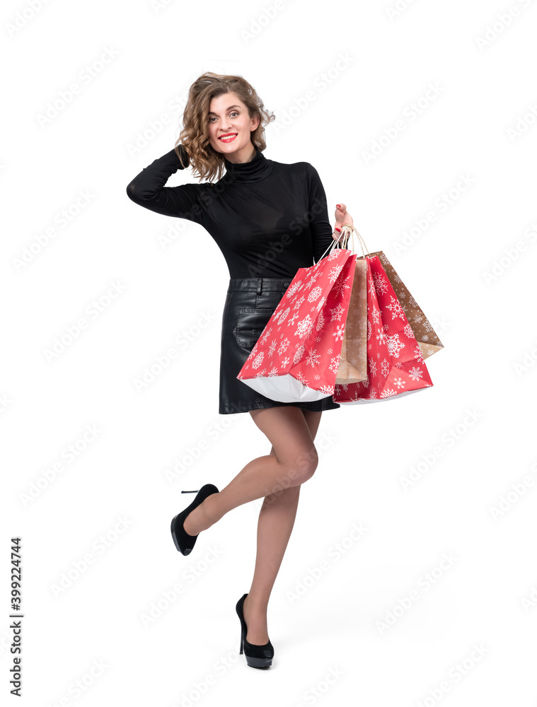 Happy young girl in black turtleneck and leather skirt with christmas shopping paper bags, isolated on white background. Happy young girl in black turtleneck and leather skirt with christmas shopping paper bags, isolated on white background.