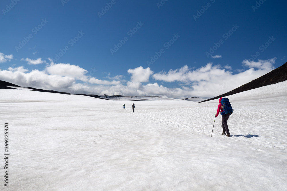 Hikers crossing snow covered pass at Eyafjallajökull volcano in the middle of Fimmvorduhals hike, summer in Iceland.