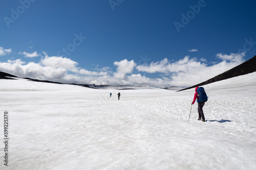 Hikers crossing snow covered pass at Eyafjallajökull volcano in the middle of Fimmvorduhals hike, summer in Iceland.