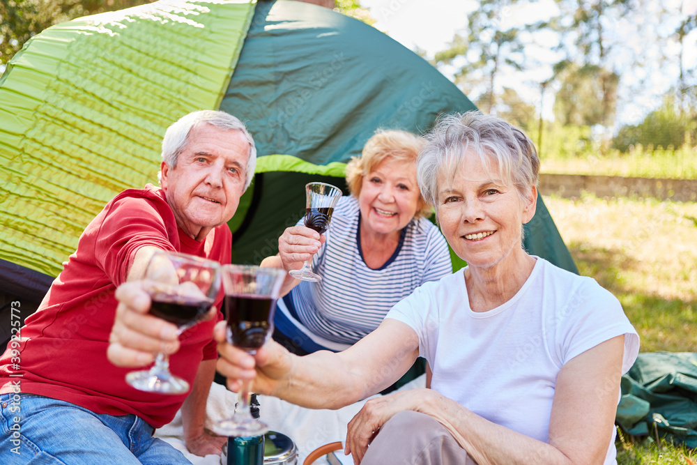 Seniors celebrate with a glass of wine while camping Stock Photo