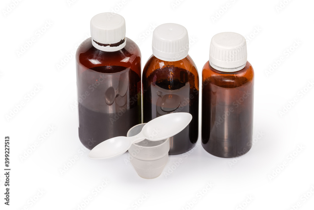 Brown bottles of liquid medicines, measuring cup and measuring spoon Brown bottles of liquid medicines, measuring cup and measuring spoon