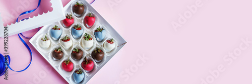 Great festive background with free space. Chocolate covered strawberries in a gift box on a pink background, dessert for Valentine's Day, romance, food as a gift. Romantic postcard with free space.