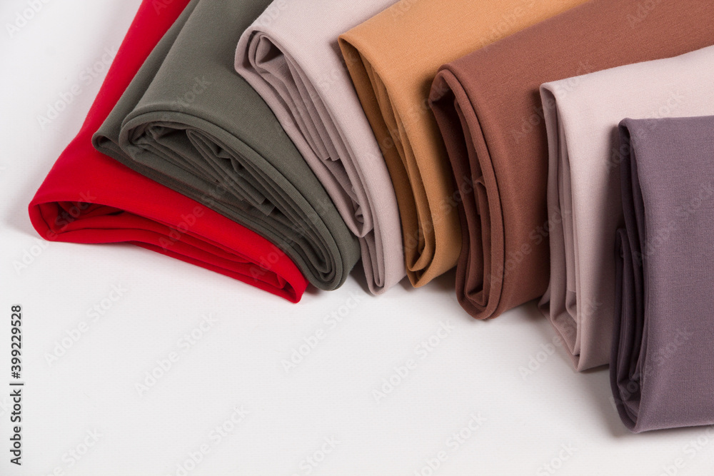 Multicolored fabrics folded in a stack top view on a white background. Multi-colored textile Multicolored fabrics folded in a stack top view on a white background. Multi-colored textile