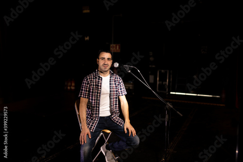 man giving monologue on stage with microphone
