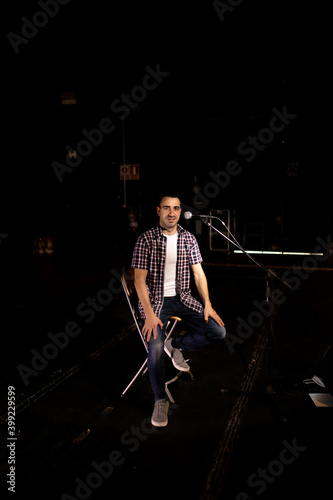 man giving monologue on stage with microphone © robcartorres
