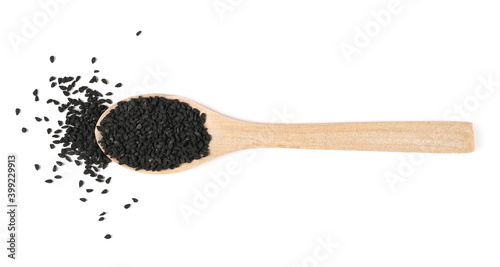 Black cumin, caraway seeds in wooden spoon isolated on white background, top view