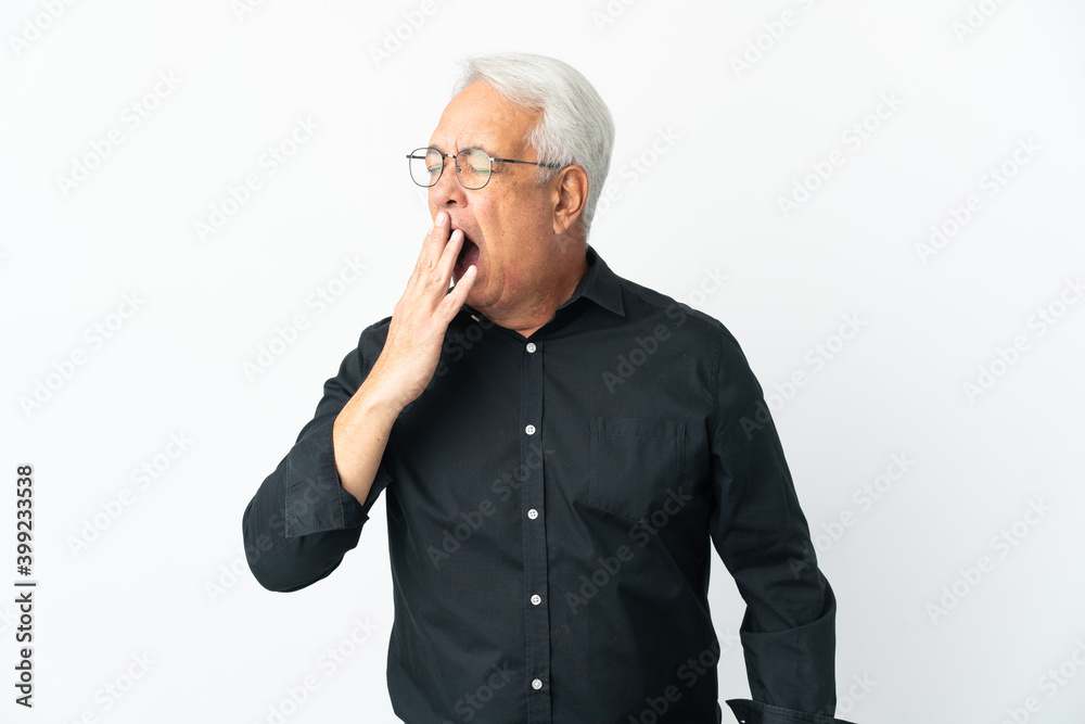 Middle age Brazilian man isolated on white background yawning and covering wide open mouth with hand Middle age Brazilian man isolated on white background yawning and covering wide open mouth with hand
