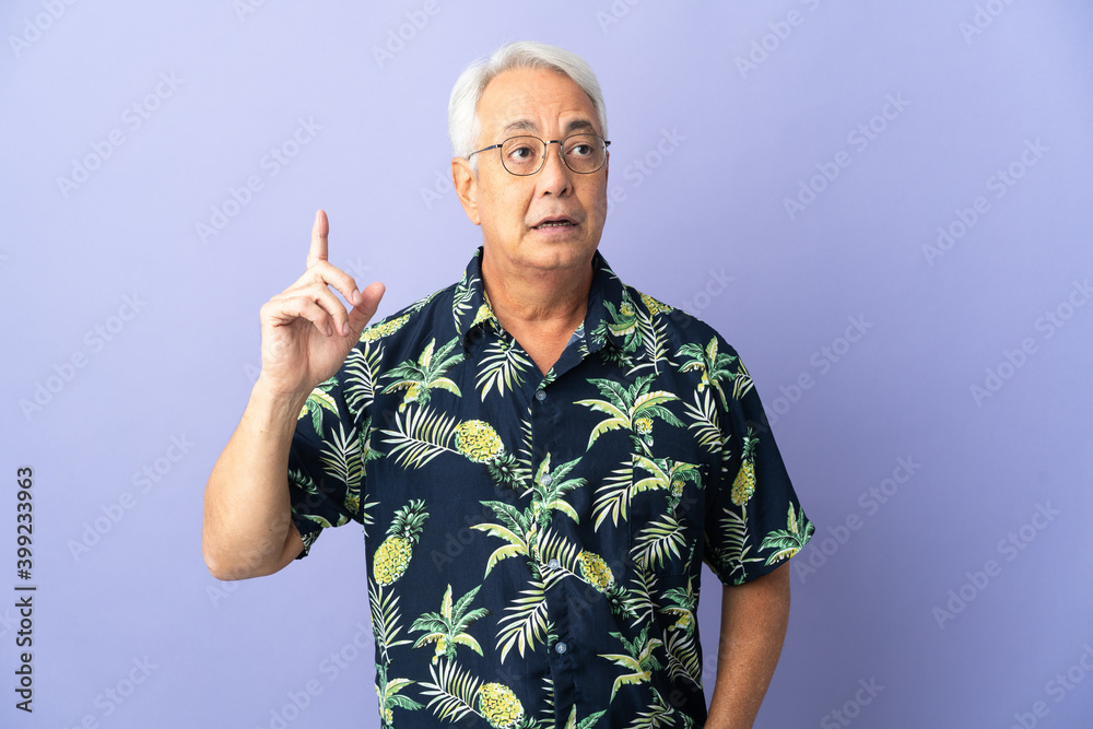 Naklejka premium Middle age Brazilian man isolated on purple background thinking an idea pointing the finger up