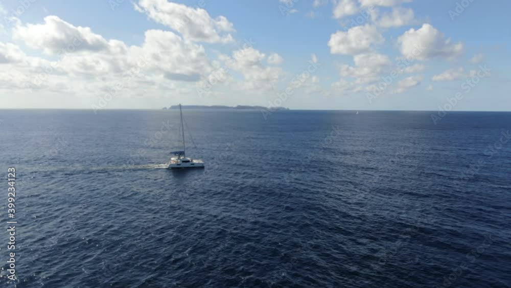 White catamaran sailing on the meditterane sea with a an amazing view of the horizon with blue sea, concept of travel, sun and holiday. White catamaran sailing on the meditterane sea with a an amazing view of the horizon with blue sea, concept of travel, sun and holiday.