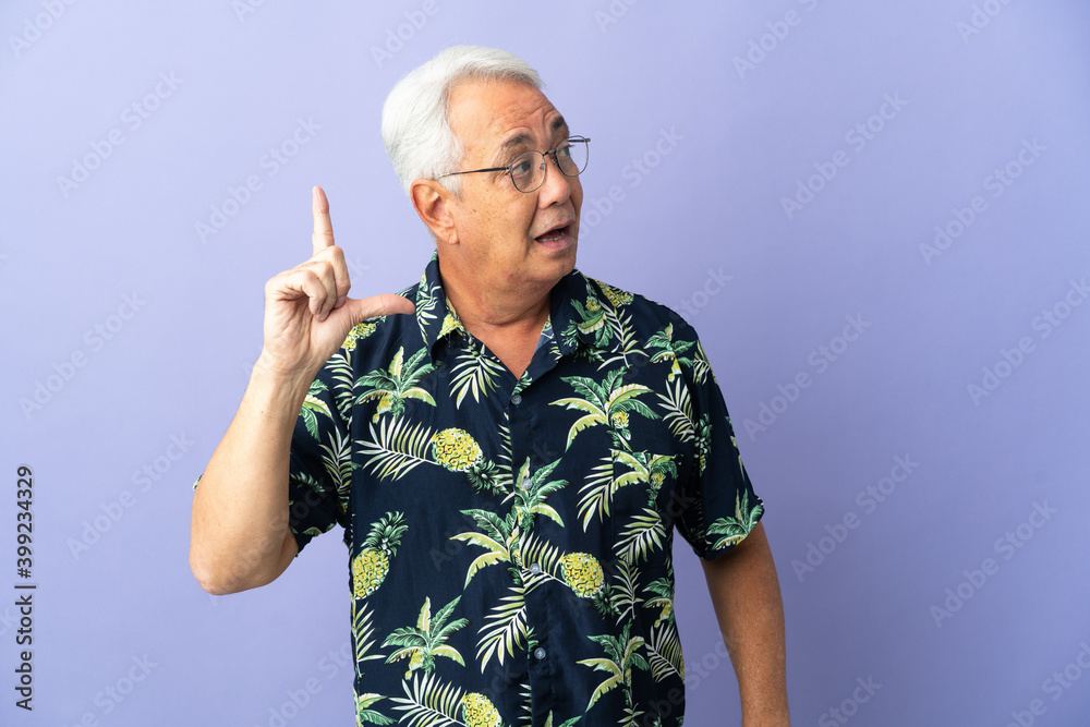 Naklejka premium Middle age Brazilian man isolated on purple background intending to realizes the solution while lifting a finger up