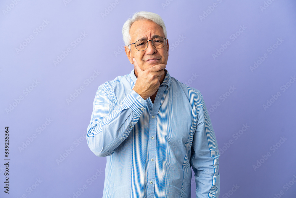 Middle age Brazilian man isolated on purple background having doubts