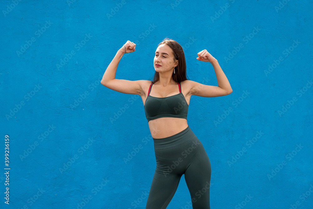 Fototapeta premium Portrait of a beautiful fitness woman in green sportwear