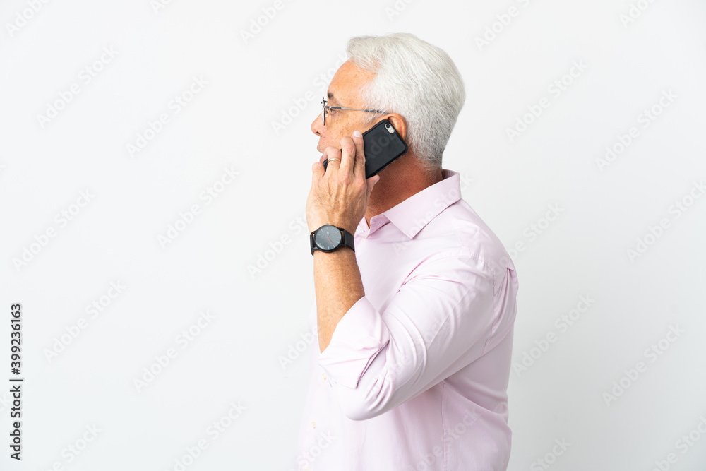 Middle age Brazilian man isolated on white background keeping a conversation with the mobile phone with someone Middle age Brazilian man isolated on white background keeping a conversation with the mobile phone with someone