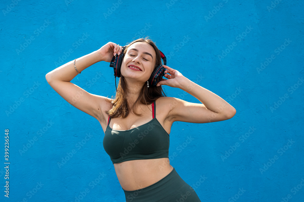 Fototapeta premium Happy fitness woman in sportear listening to music isolated
