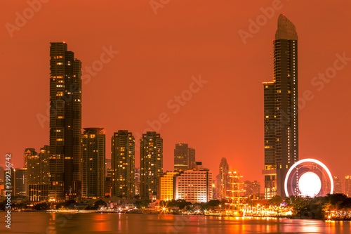 Blurred abstract background of high-rise buildings built by the river, lit at night, the distribution of residences of today's capital so
