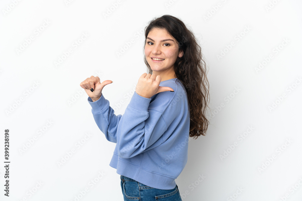 Teenager Russian girl isolated on white background pointing to the side to present a product Teenager Russian girl isolated on white background pointing to the side to present a product