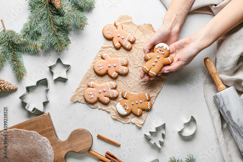 Female hands with gingerbread cookies on white background, top view