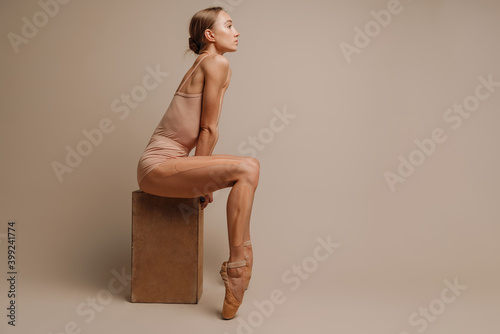 Beautiful young lady ballerina sitting isolated photo