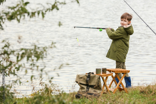 Little boy fishing on river