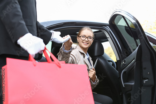Chauffeur helping businessw...