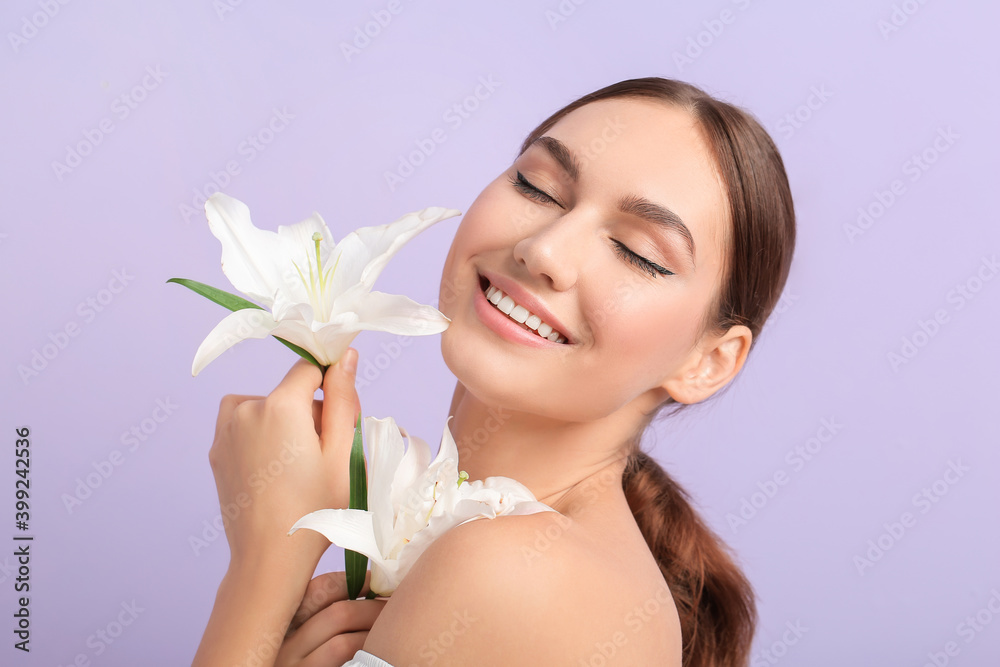 Beautiful young woman with fresh lilies on color background